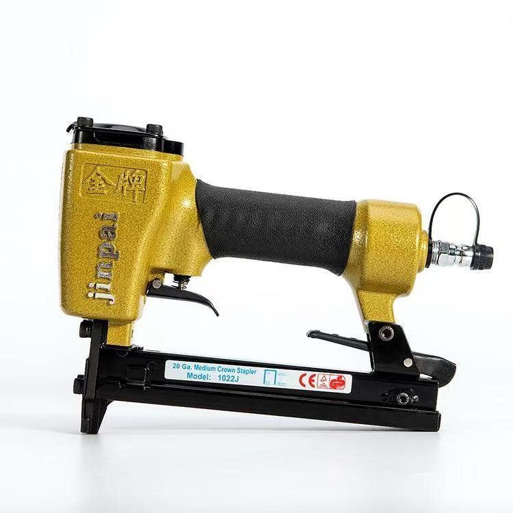 Staples gun used for furniture upholstery and woodworking applications with compatible industrial staples.